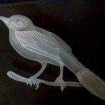 A bird etched on flat plate glass.