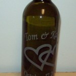 An etched glass wine bottle personalized for a wedding gift.