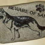 A sancarved rock depicting a dog graphic.